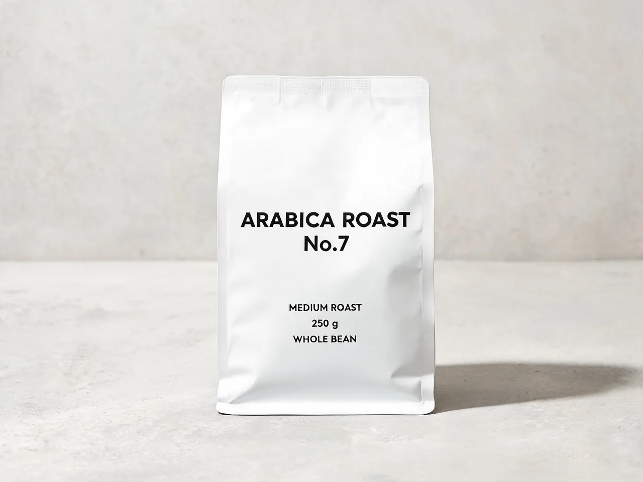 Белый пакет кофе на бетоне с крупной надписью ARABICA ROAST No.7 и мелкими строками MEDIUM ROAST, 250 g, WHOLE BEAN