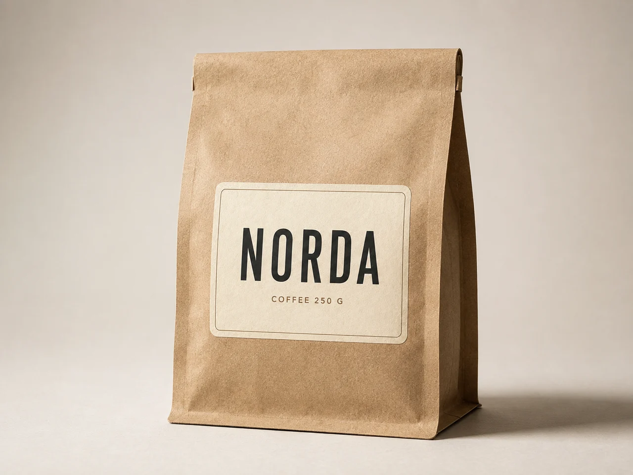 Кремовая этикетка NORDA COFFEE на крафтовом пакете с плоским дном: видно волокно бумаги, боковой свет